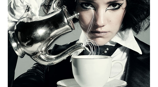 dark haired woman model pours teacup mad hatter