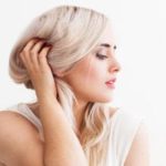 Blonde woman touching hair