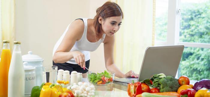 young woman healthy eating laptop research fruits vegetables