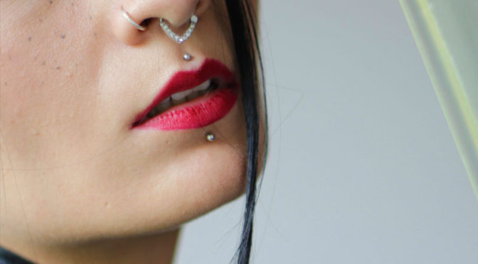 Millennial with nose piercing woman girl red lip