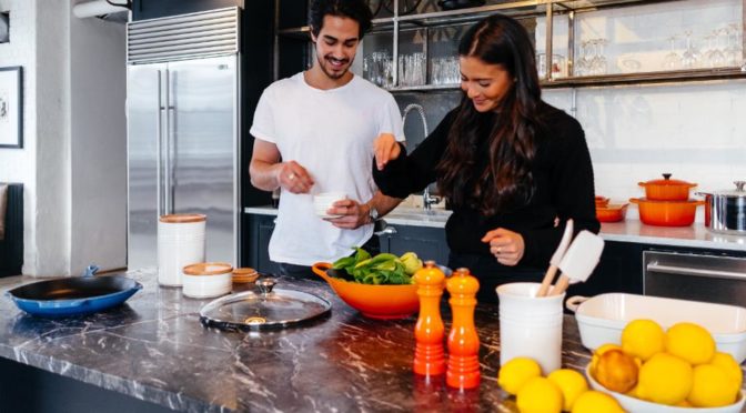 happy vegan couple young cooking with vegetables