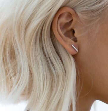 millennial woman waering simple silver bar earrings