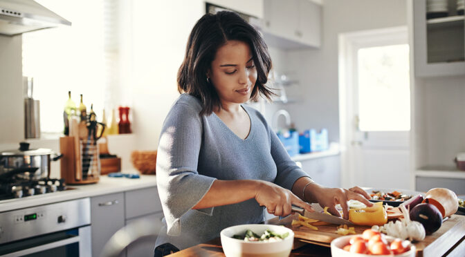 Shot of an attractive young woman cooking at home