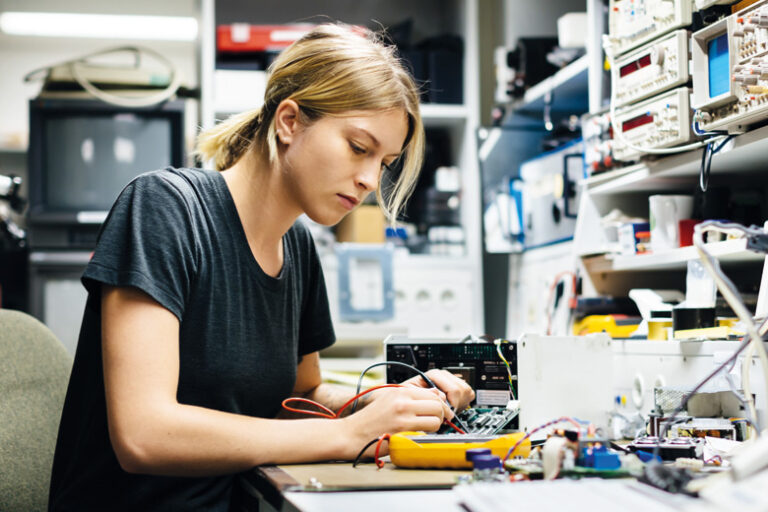 female-engineer-measuring-voltage-on-conductor-board PCB