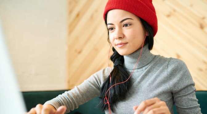 woman in red beanie with headphones turtleneck