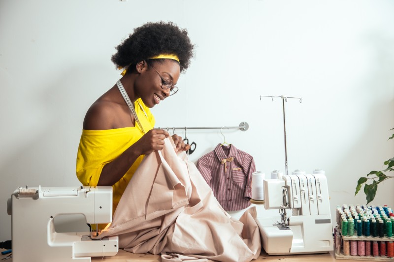 Black woman sewing clothes tailor clothing company